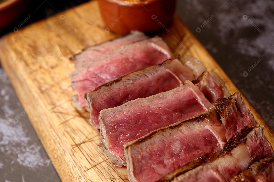 Costela curta ou Rib Premium. Bife grelhado em Parrilla argentina com marcas de grelha em uma tábua de madeira ao fundo. Comida brasileira JPG