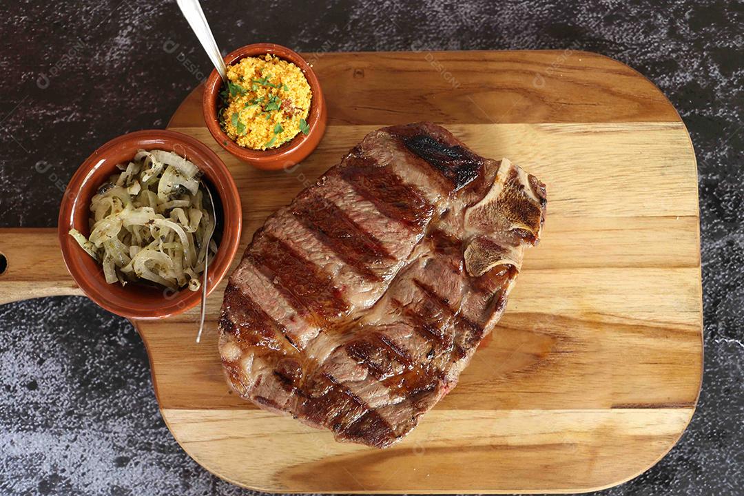 Costela curta ou Rib Premium. Bife grelhado em Parrilla argentina com marcas de grelha em uma tábua de madeira ao fundo. Comida brasileira JPG