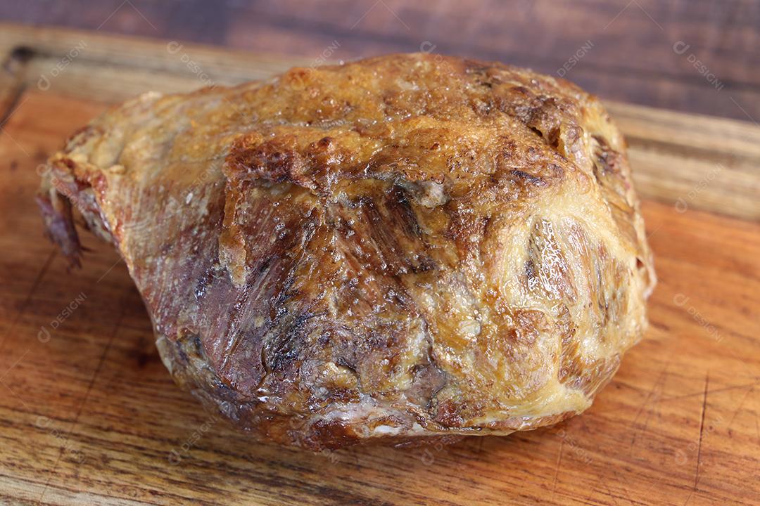 Cupim ou Cupim. Tradicional cordão brasileiro de boi Nelore cortado sob uma tábua de madeira com uma faca de churrasco JPG