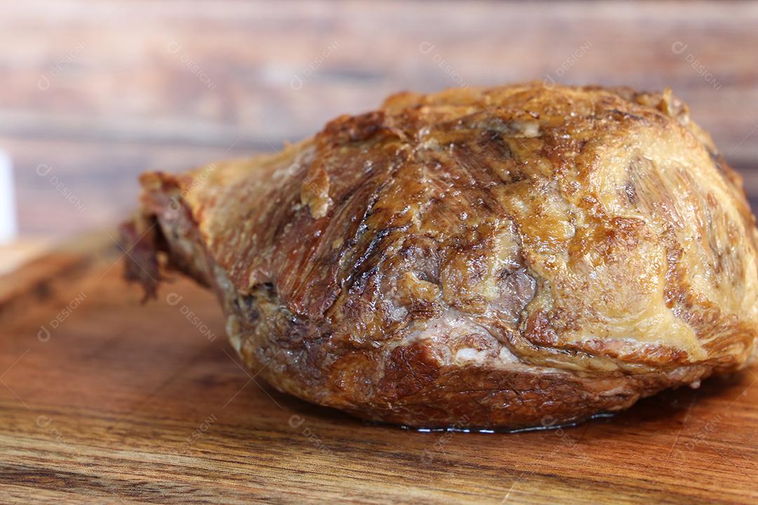 Cupim ou Cupim. Tradicional cordão brasileiro de boi Nelore cortado sob uma tábua de madeira com uma faca de churrasco JPG