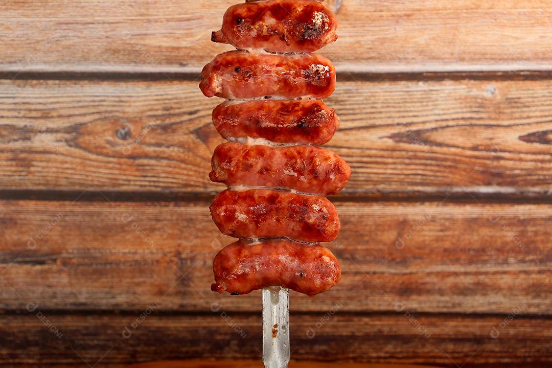 salsicha em espetos em um fundo de madeira JPG