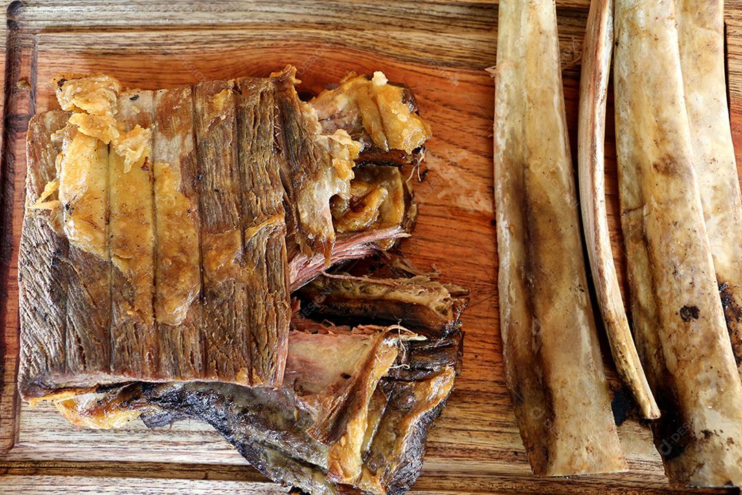 Costela, costela. Deliciosa costela assada com ossos grandes. Servido em uma tábua de madeira JPG