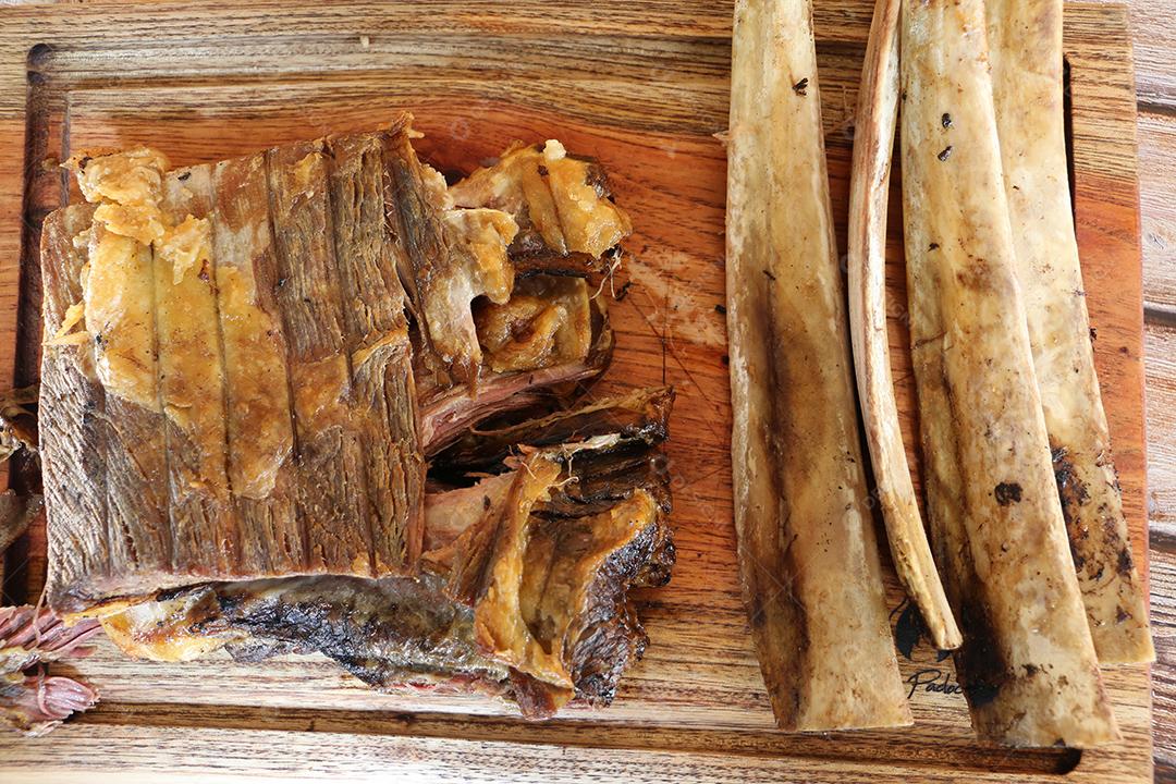 Costela, costela. Deliciosa costela assada com ossos grandes. Servido em uma tábua de madeira JPG