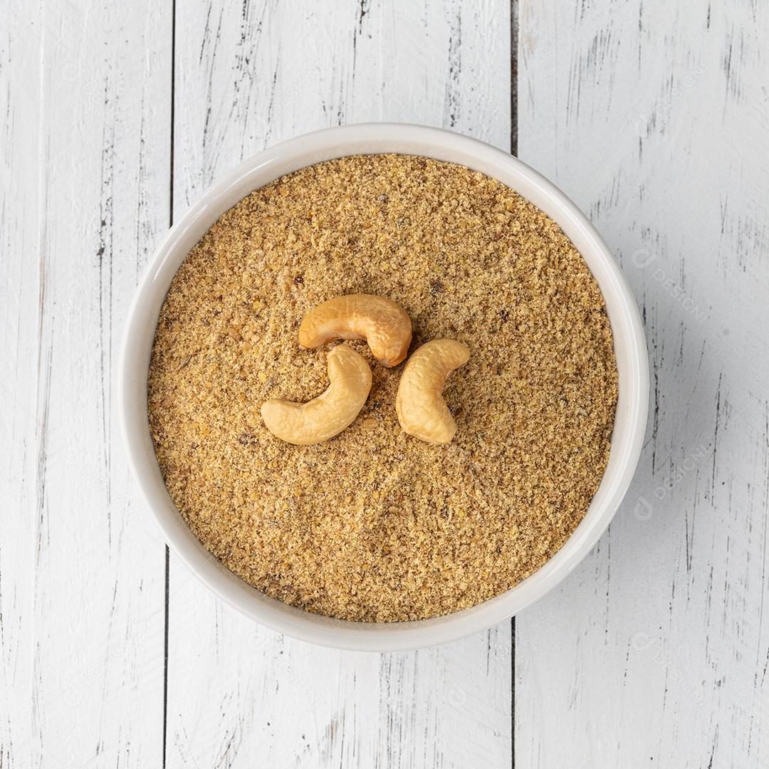 Farinha de castanha de caju em uma tigela sobre mesa de madeira. Farinha sem glúten JPG