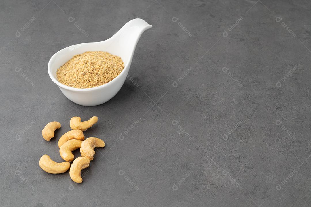Farinha de castanha de caju em uma tigela sobre fundo de pedra. Sem glúten JPG
