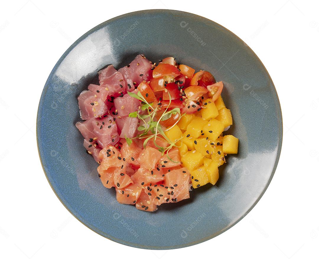 Salmão, atum, tomate e manga picar em uma tigela azul isolada sobre fundo branco