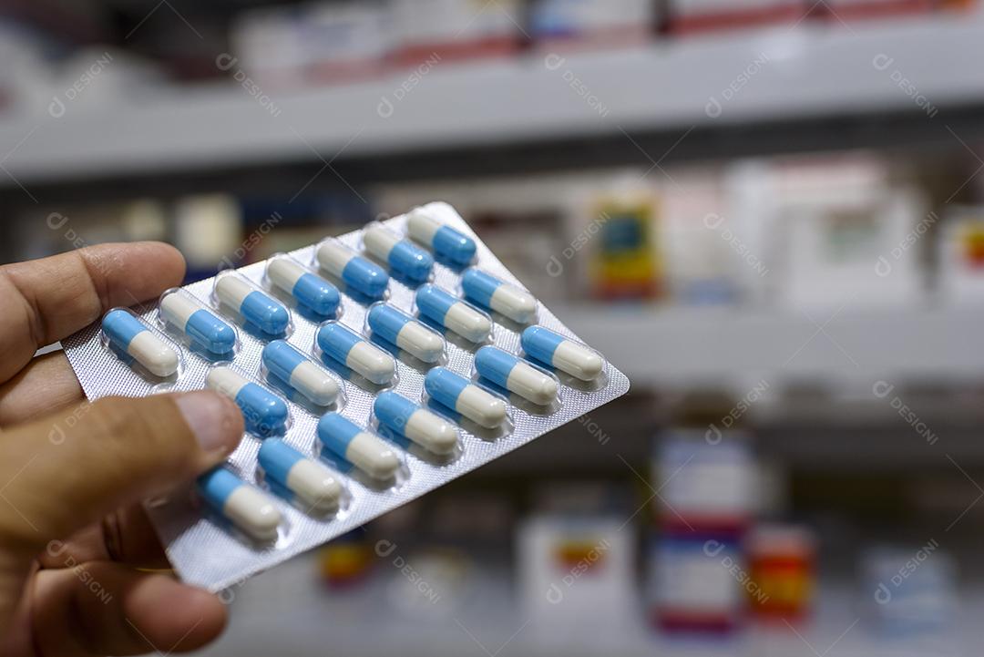pílulas no pacote mão segurando comprimidos em uma farmácia Imagem JPG