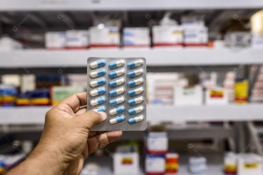 pílulas no pacote mão segurando comprimidos em uma farmácia Imagem JPG