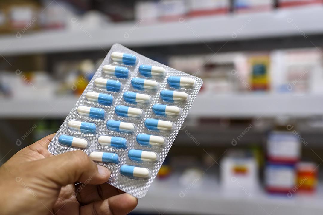 pílulas no pacote mão segurando comprimidos em uma farmácia Imagem JPG