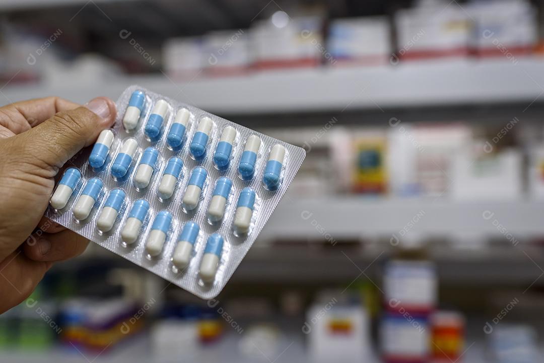 Comprimidos no pacote mão segurando pílulas em uma farmácia Imagem JPG