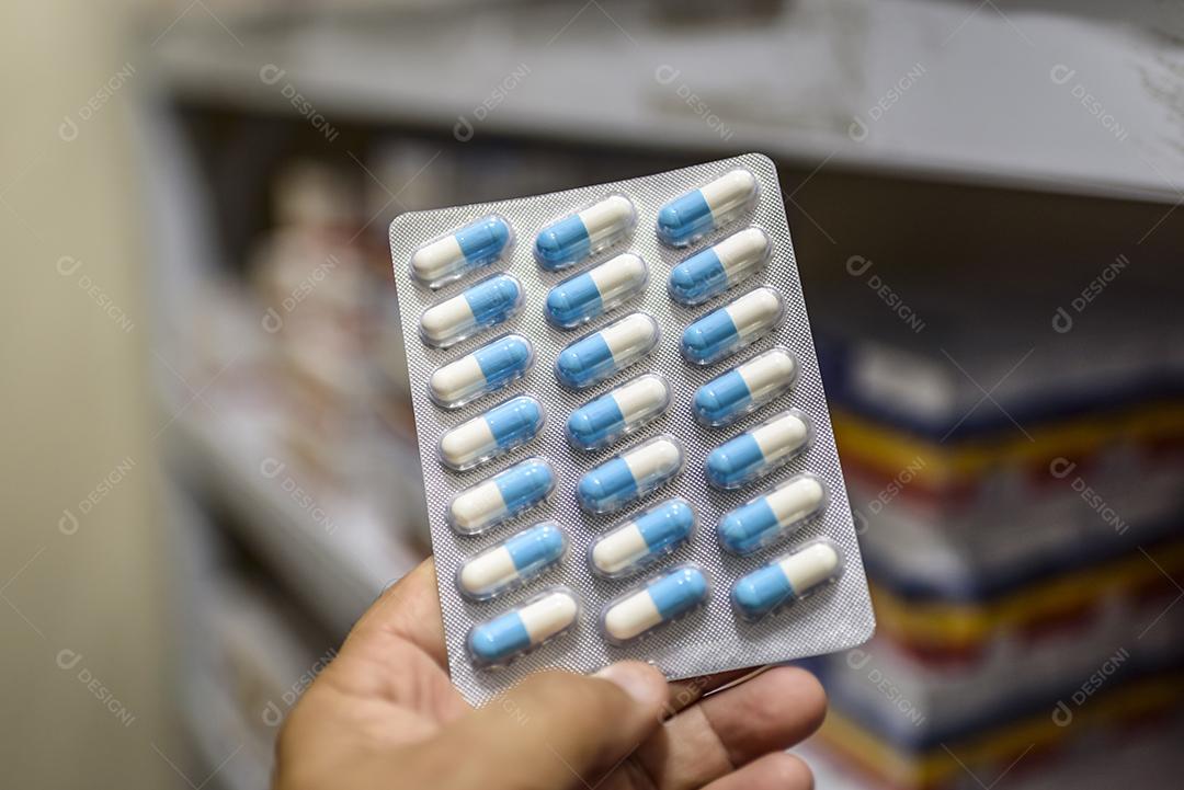 Comprimidos no pacote mão segurando pílulas em uma farmácia Imagem JPG