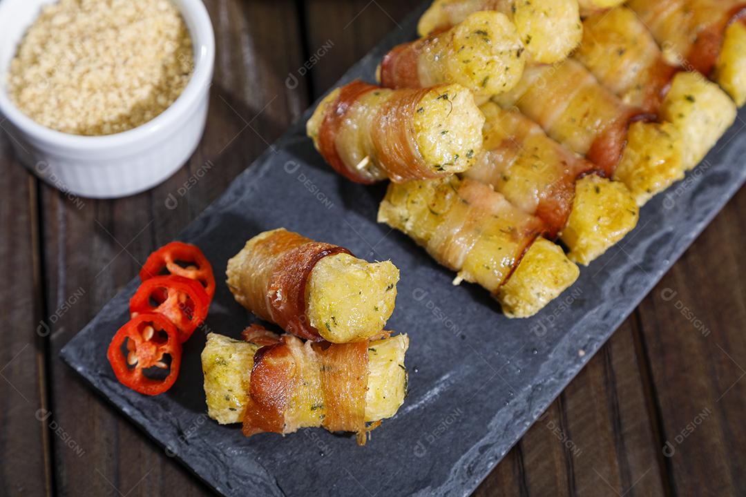 Espetinhos de mandioca enrolados no bacon medalhão de mandioca Imagem JPG