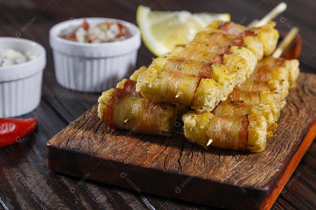 Espetinhos de mandioca enrolados no bacon medalhão de mandioca Imagem JPG