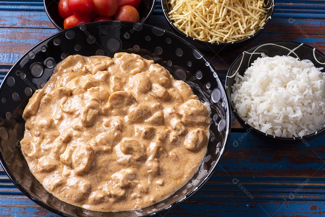 Estrogonofe de frango acompanhado de arroz, salada e palha de batata JPG