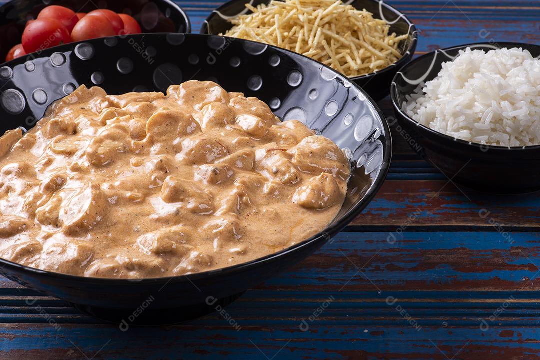 Estrogonofe de frango acompanhado de arroz, salada e palha de batata JPG