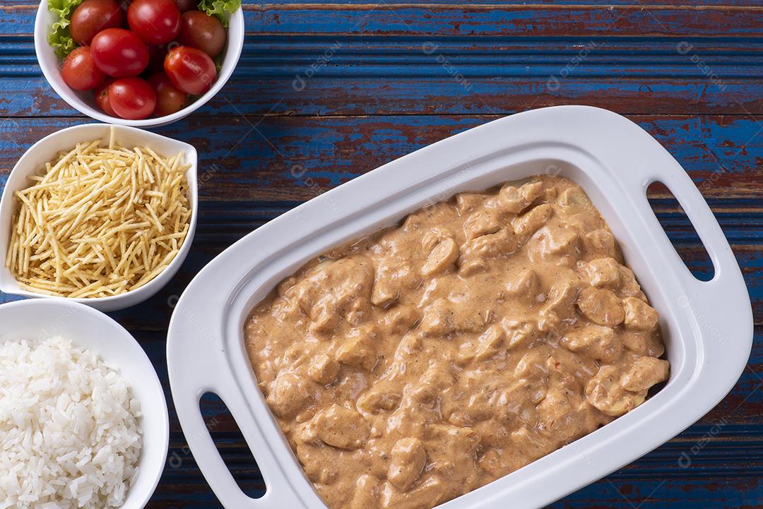 Estrogonofe de frango acompanhado de arroz, salada e palha de batata JPG