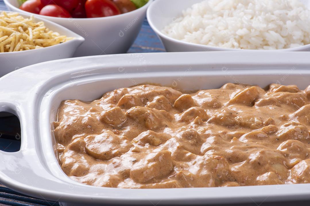 Estrogonofe de frango acompanhado de arroz, salada e palha de batata JPG