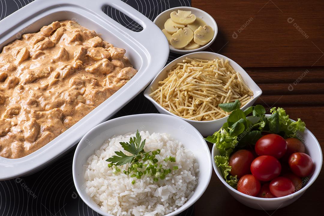 Estrogonofe de frango acompanhado de arroz, salada e palha de batata JPG