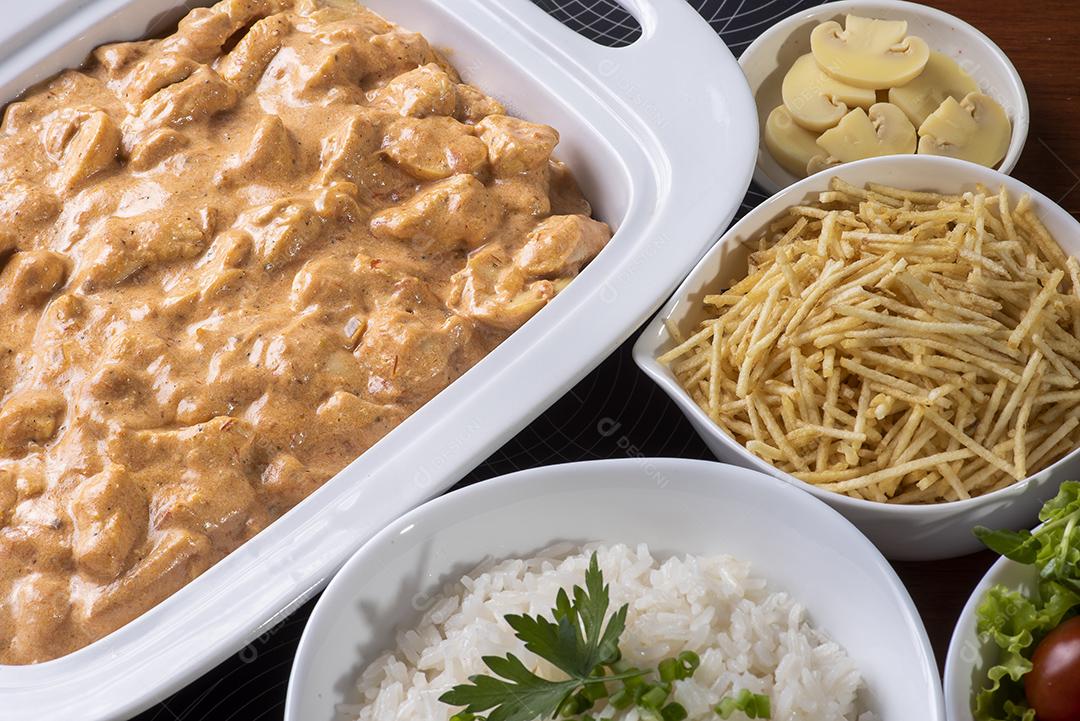 Estrogonofe de frango acompanhado de arroz, salada e palha de batata JPG