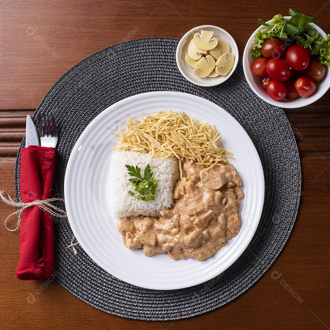 Estrogonofe de frango acompanhado de arroz, salada e palha de batata JPG