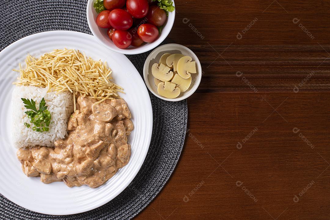 Estrogonofe de frango acompanhado de arroz, salada e palha de batata JPG