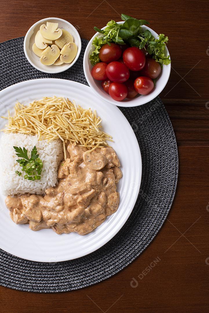 Estrogonofe de frango acompanhado de arroz, salada e palha de batata JPG