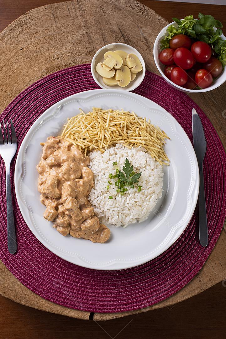 Estrogonofe de frango acompanhado de arroz, salada e palha de batata JPG