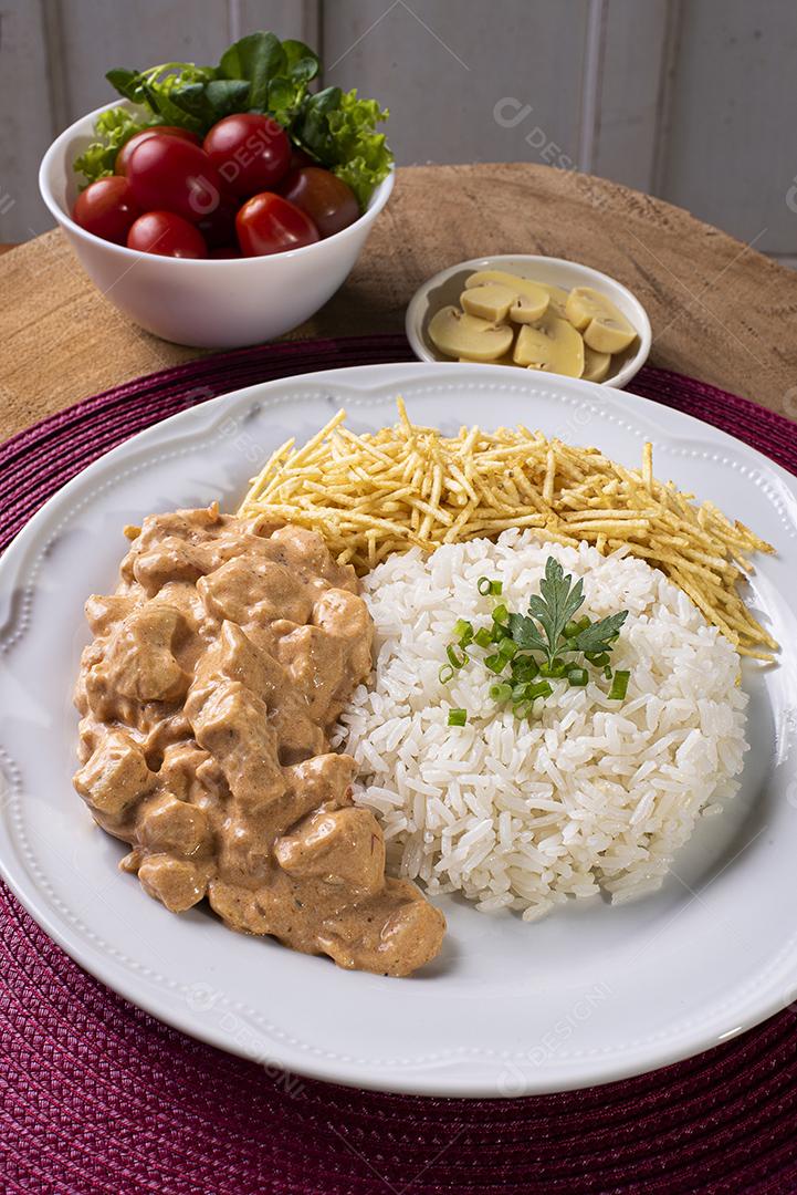 Estrogonofe de frango acompanhado de arroz, salada e palha de batata JPG