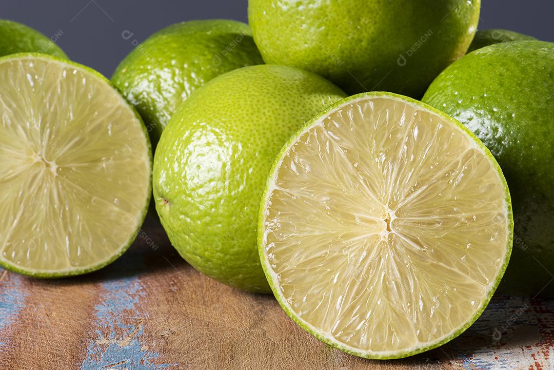 Limão cortado ao meio com alguns limões JPG