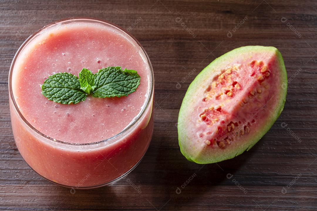 Delicioso suco de goiaba vermelha ao lado de uma fatia de goiaba folhas Imagem JPG