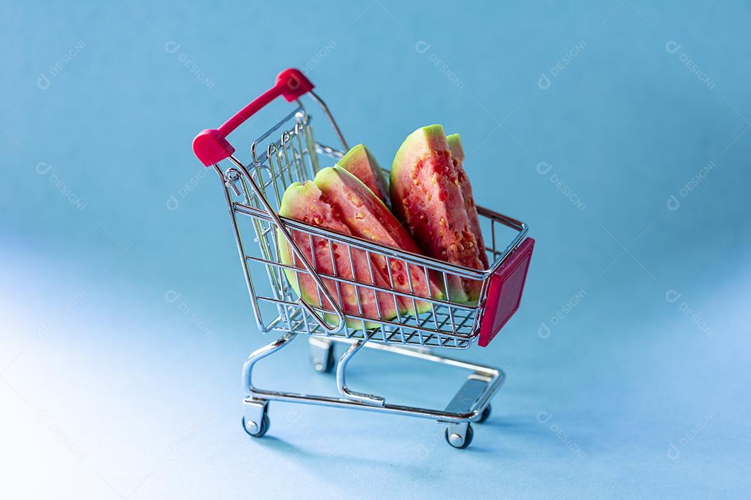 Fotos Plantas de goiaba vermelha dentro do carrinho de supermercado em fundo azul