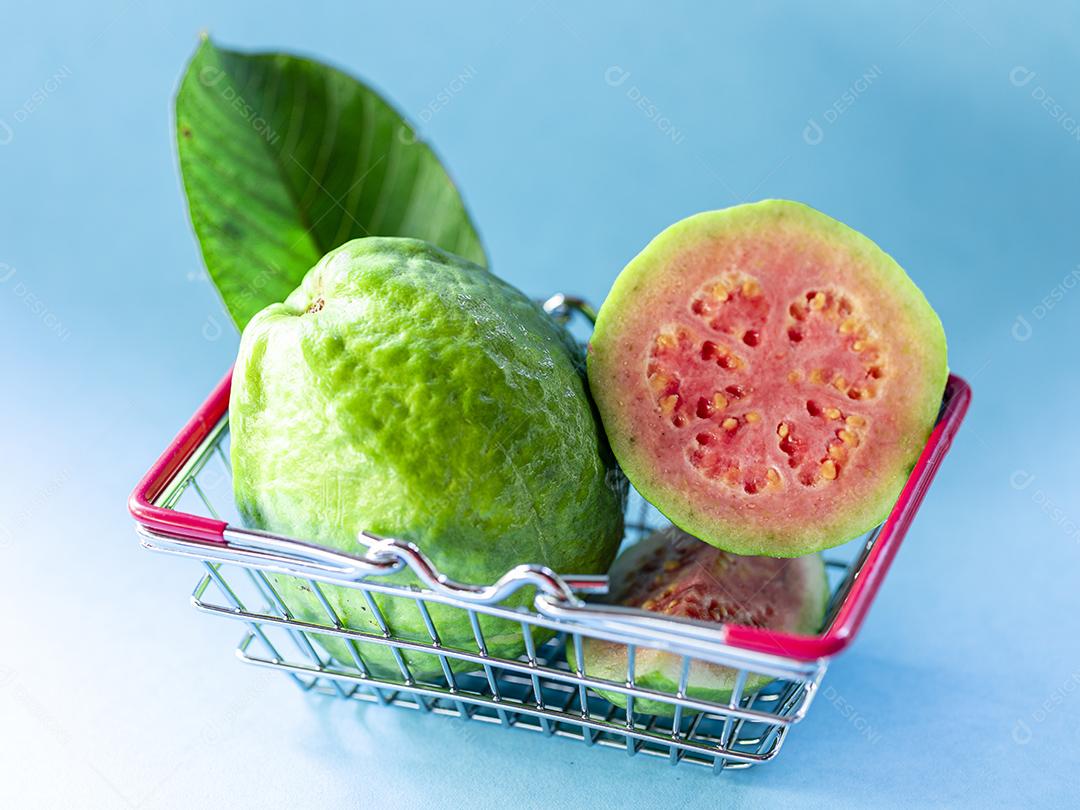 Fotos Plantas de goiaba vermelha dentro do carrinho de supermercado em fundo azul