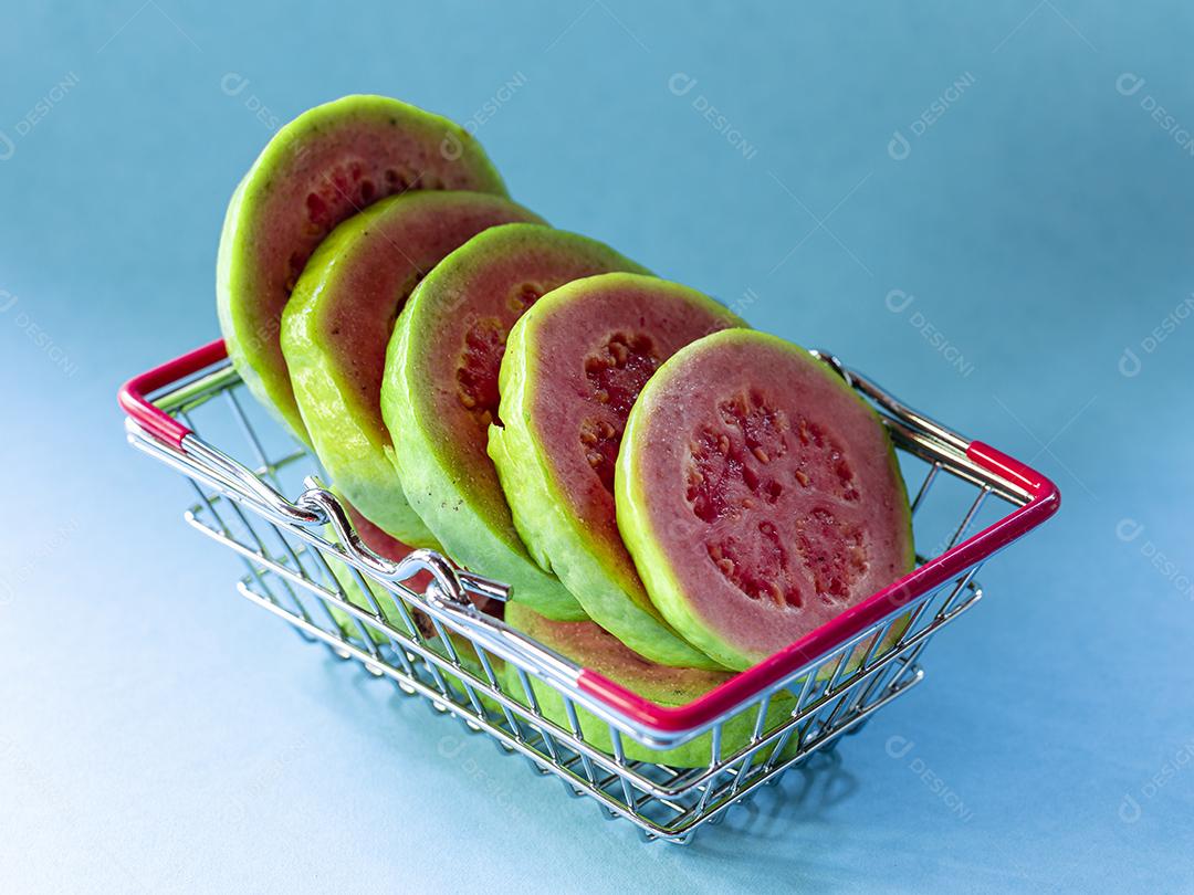 Fotos Plantas de goiaba vermelha dentro do carrinho de supermercado em fundo azul