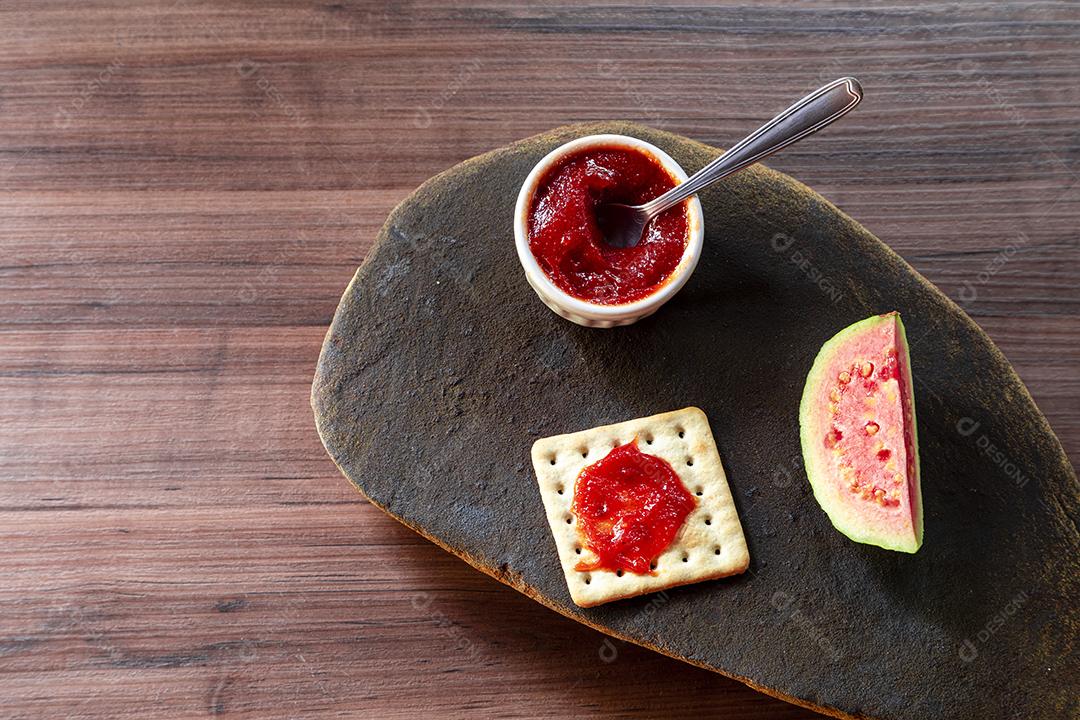 Fotos Biscoito de sal e água tigela com geléia de goiaba e fatia de goiaba em cima de textura