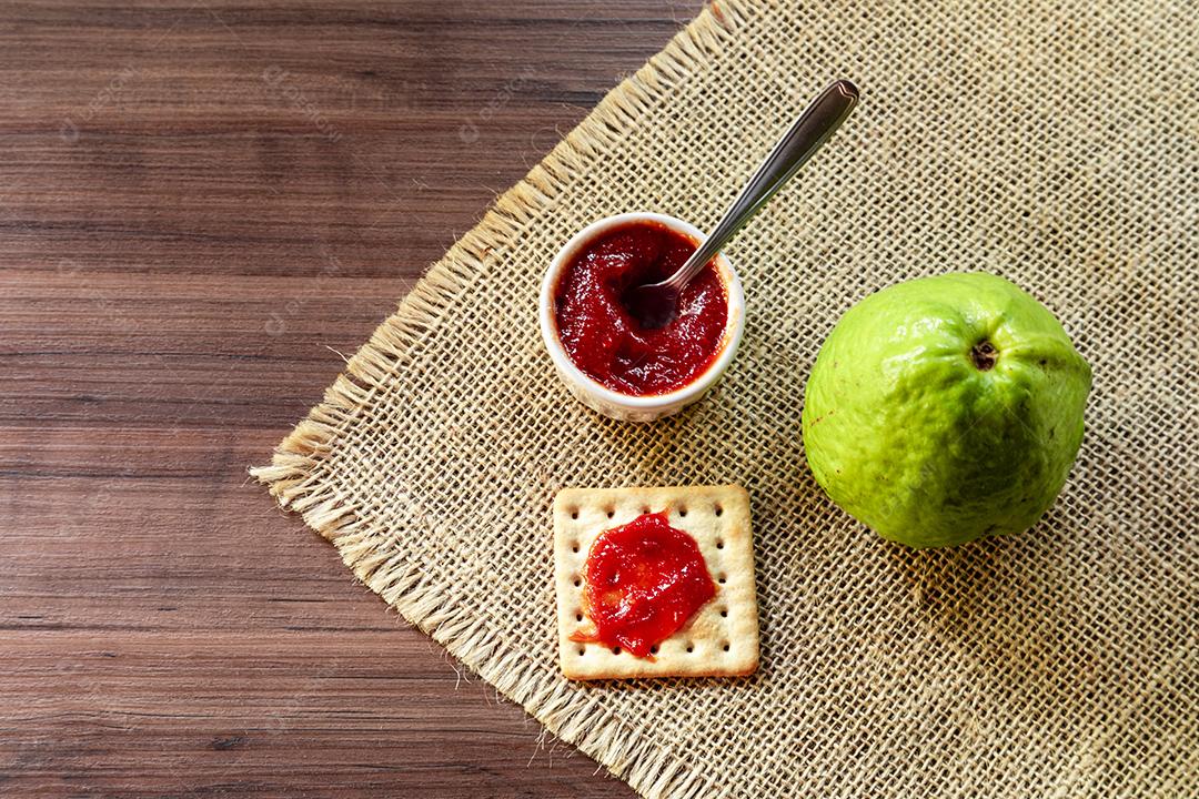 Fotos Biscoito de sal e água tigela com geléia de goiaba e fatia de goiaba em cima de textura