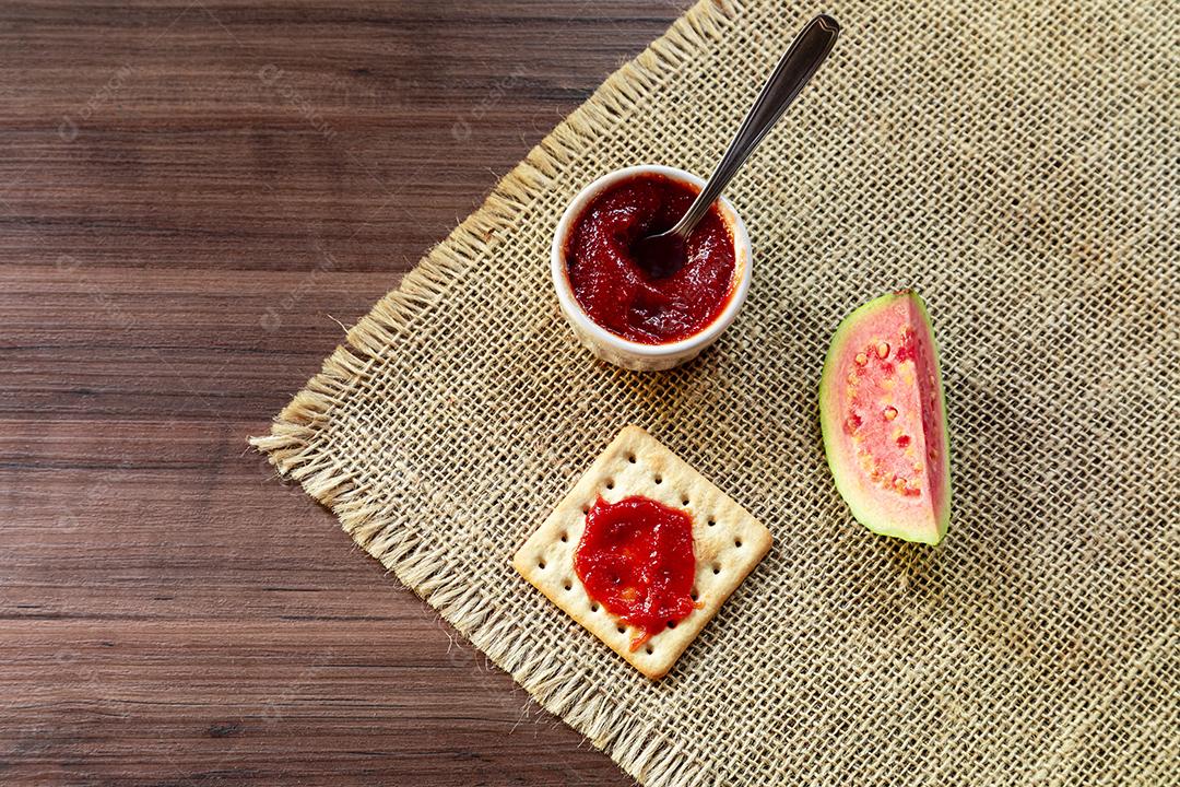 Fotos Biscoito de sal e água tigela com geléia de goiaba e fatia de goiaba em cima de textura