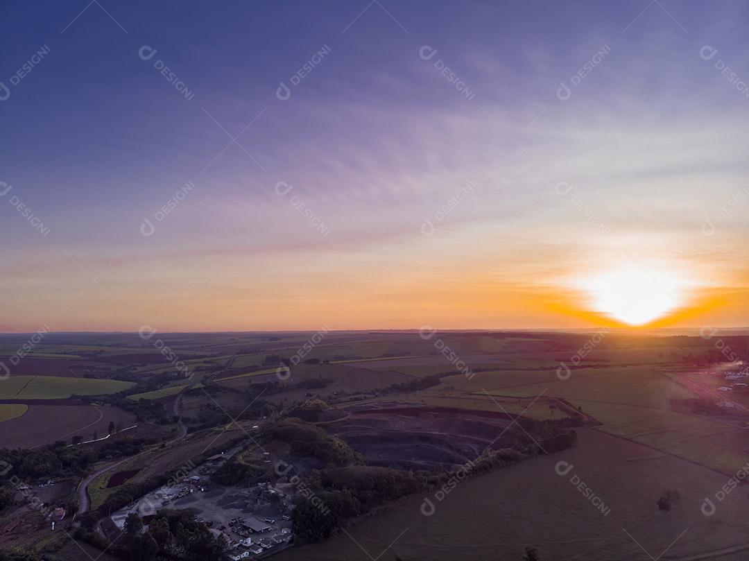 Um belo pôr do sol atrás de um buraco de pedreira Imagem JPG
