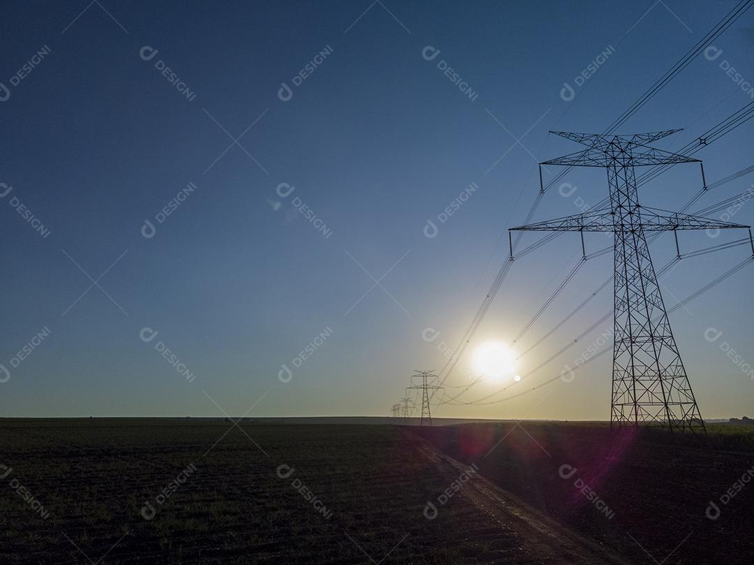 Pôr do sol entre torres de energia Imagem JPG