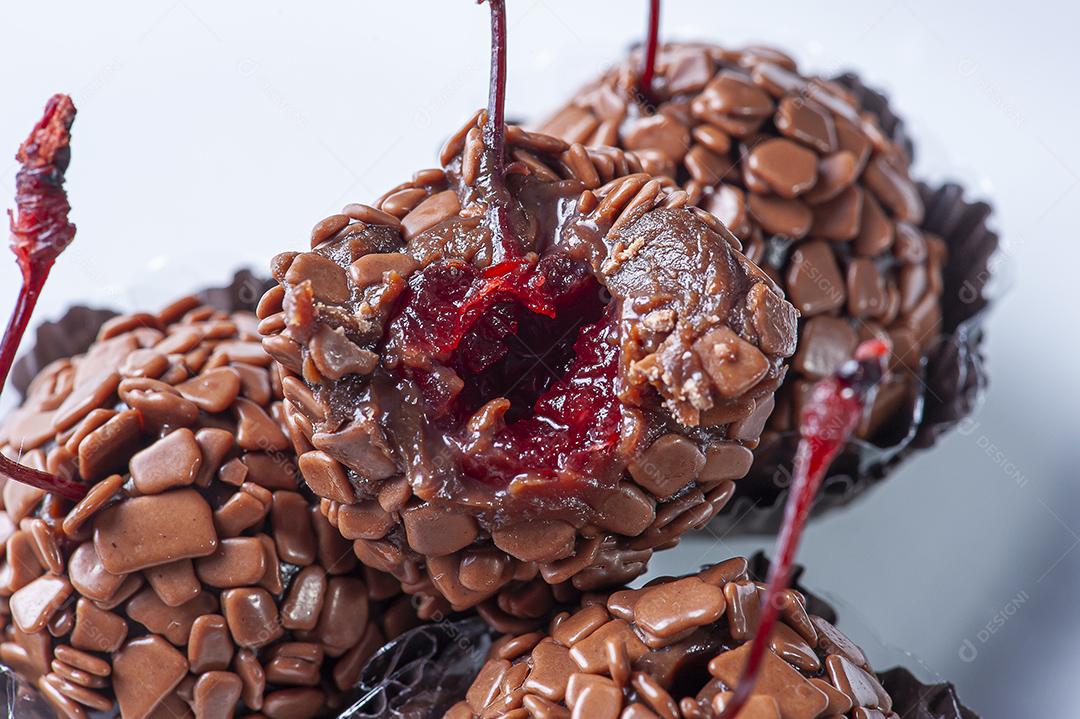 Brigadeiro de cereja gourmet. Brigadeiro mordido mostrando dentro