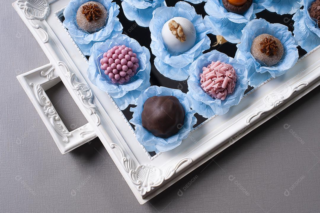 Vários tipos de brigadeiro gourmet em uma bandeja espelhada. Típico