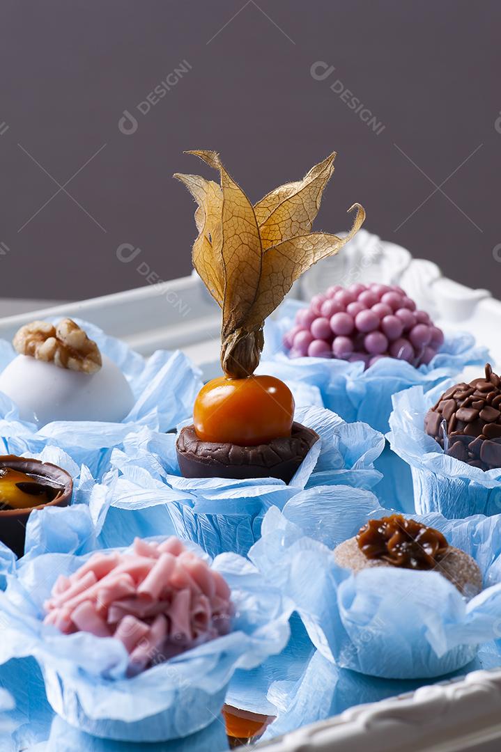 Vários tipos de brigadeiro gourmet em uma bandeja espelhada. Típico