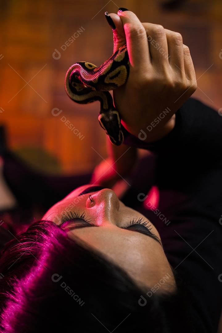 Modelo japonês em ensaio com cobra no estúdio fotográfico Imagem JPG