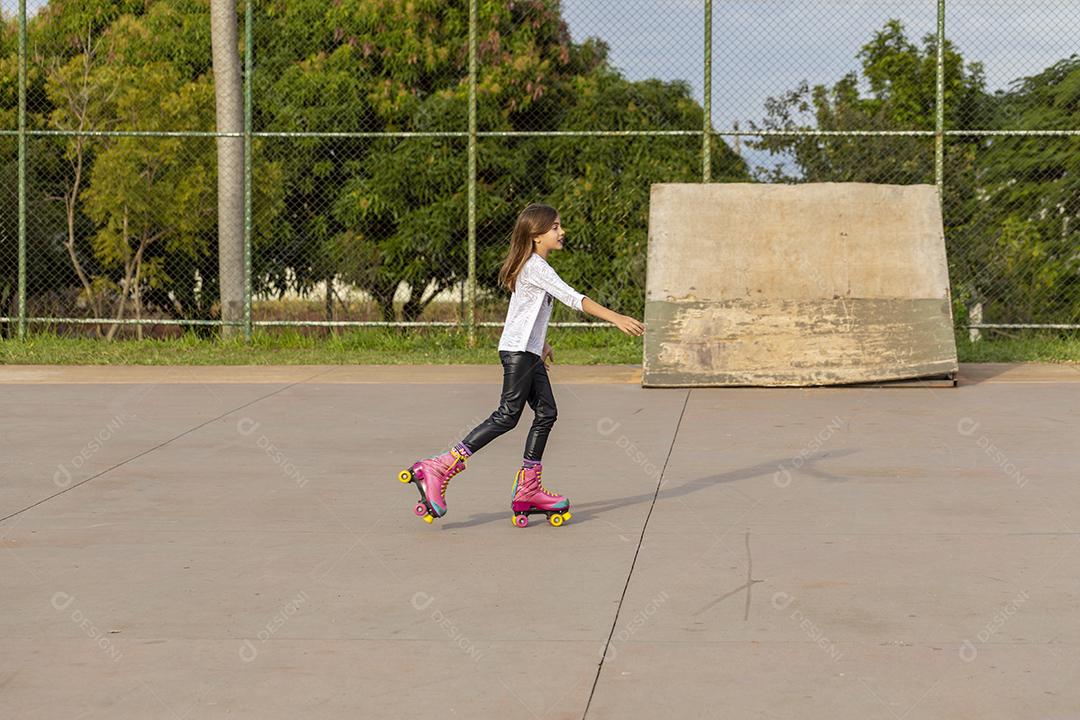 Garota andando de patins em uma quadra Imagem JPG