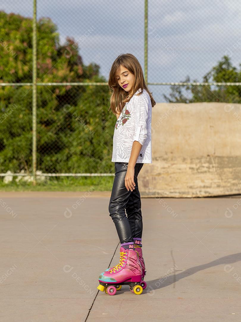 Garota andando de patins em uma quadra Imagem JPG