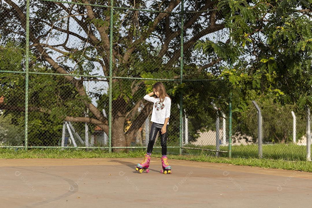 Garota andando de patins em uma quadra Imagem JPG