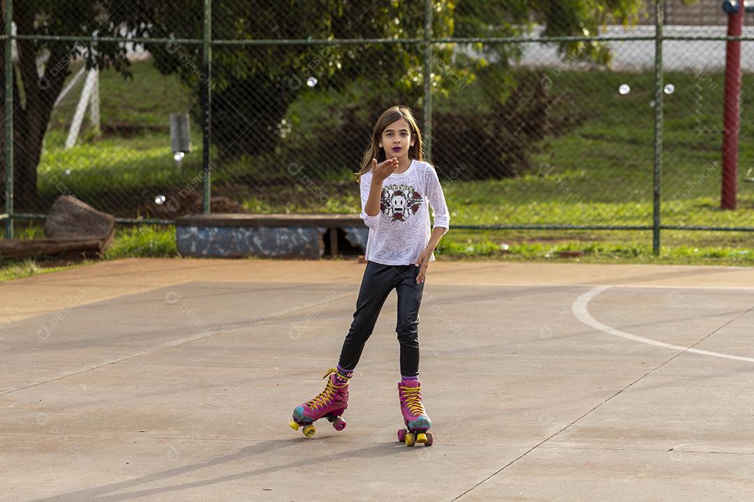 Garota andando de patins em uma quadra Imagem JPG