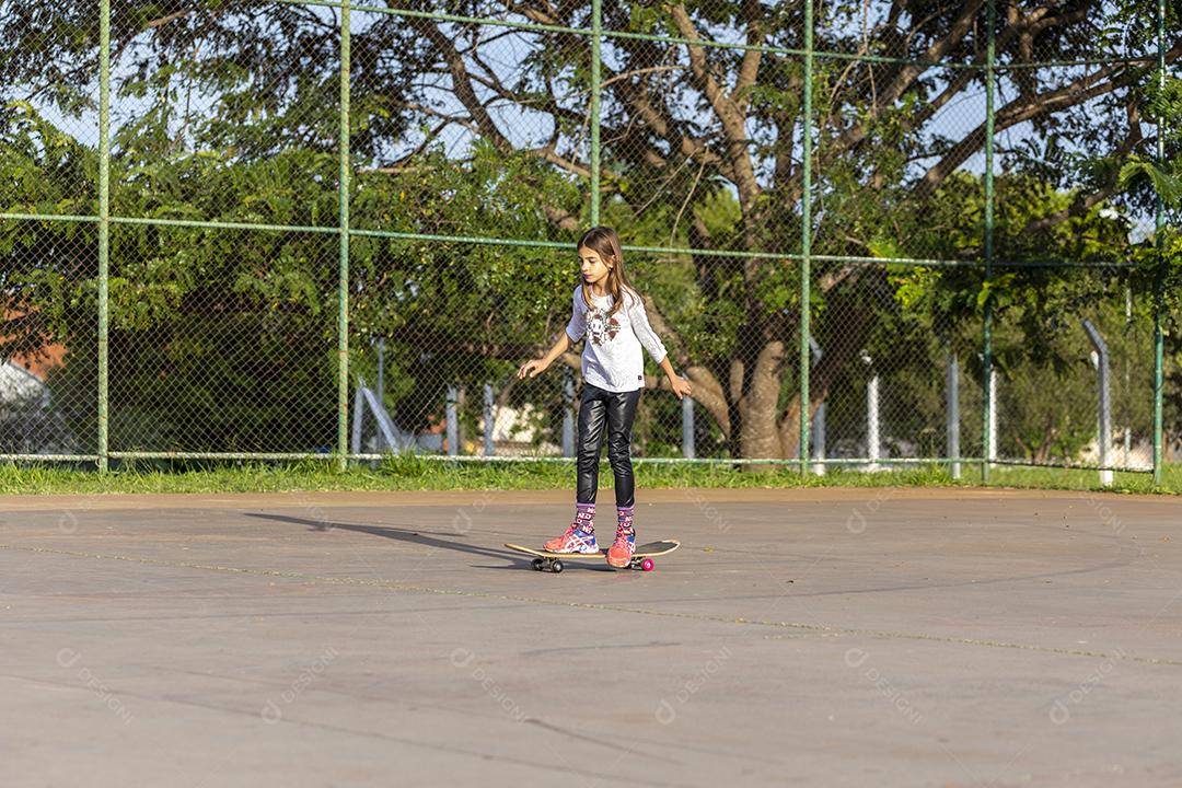 Garota andando de patins em uma quadra Imagem JPG