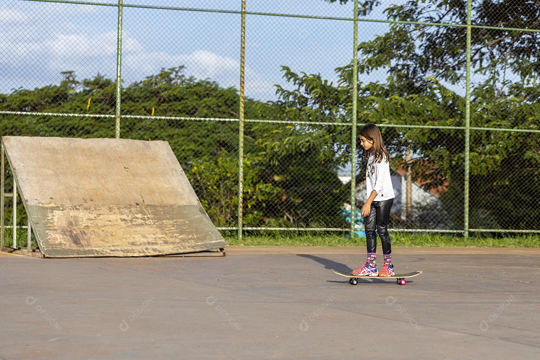 Garota andando de patins em uma quadra Imagem JPG