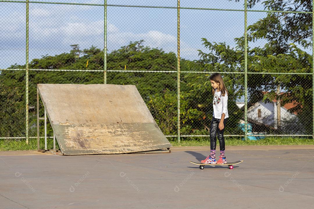 Garota andando de skate em uma quadra Imagem JPG