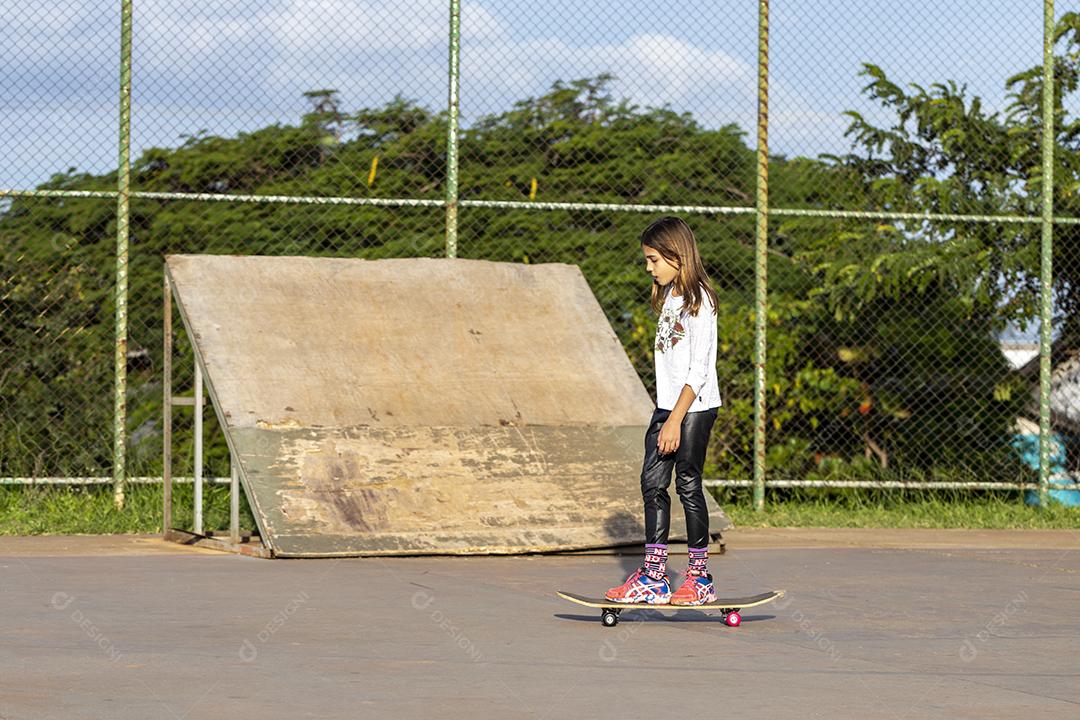 Garota andando de skate em uma quadra Imagem JPG